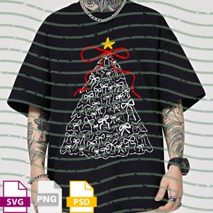 Può includere: T-shirt nero con un design ad albero di Natale fatto di fiocchi bianchi e una stella gialla. L'albero è delineato con un nastro rosso. La maglietta ha un motivo a righe verdi.