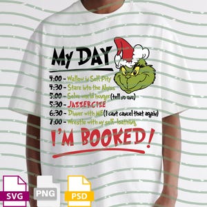 May include: White t-shirt with a Grinch graphic wearing a Santa hat. The shirt features the text "My Day" and a schedule including "I'M BOOKED!" in red. The schedule includes activities like "Wallow in Self Pity" and "JAZZERCIZE."