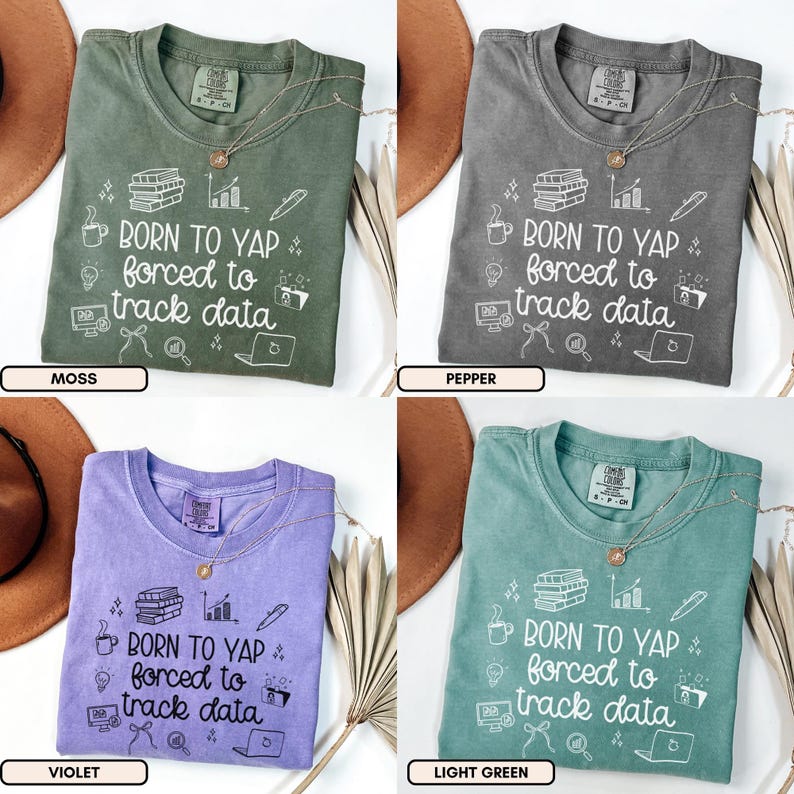 May include: Four t-shirts in moss, pepper, violet, and light green. Each shirt has the text "BORN TO YAP forced to track data" with graphic icons. A gold necklace is on each shirt.