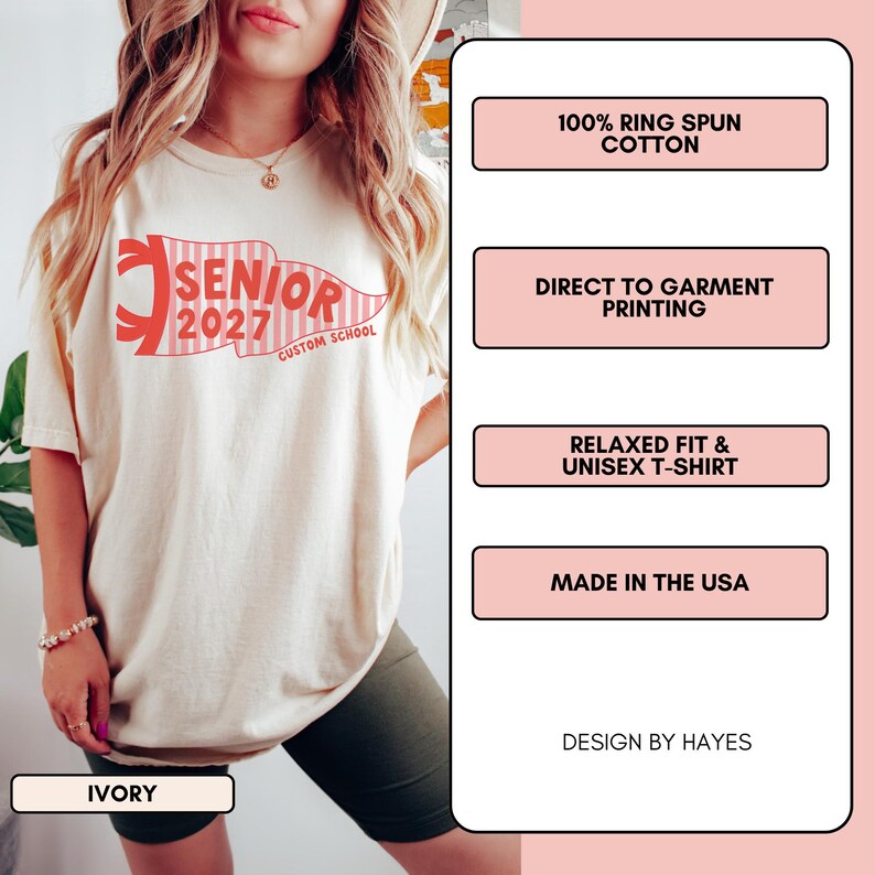 May include: An ivory t-shirt featuring a red and white striped pennant graphic with the text SENIOR 2027 CUSTOM SCHOOL. The shirt is made of 100% ring spun cotton, uses direct to garment printing, has a relaxed fit, and is made in the USA.