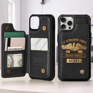 May include: Black leather phone case with a wallet feature. The case has a gold emblem that reads "U.S. Submarine Force" and "Silent Service". The wallet section holds cards and a dollar bill. The name "HENRY" is displayed on the case.