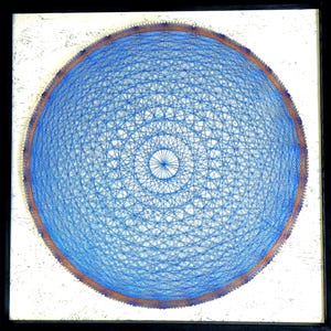 Op de afbeelding: Een ingelijst kunstwerk met een blauw touwontwerp in een cirkelvormig patroon. De string art staat tegen een witte achtergrond, met een dunne oranje rand rond de blauwe cirkel. De lijst is zwart.