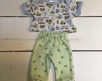 Maglietta con fantasia di veicoli verde, blu e bianca e un paio di pantaloni verde chiaro con fantasia, realizzati per la bambola da 14 pollici.