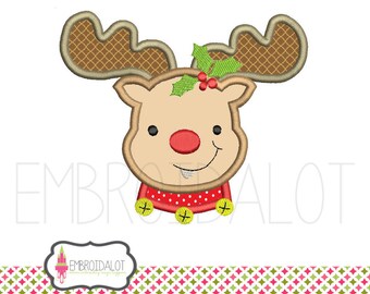 May include: A brown and white reindeer with a red nose and a red and white polka dot collar with bells. The reindeer has a green holly sprig on its head.