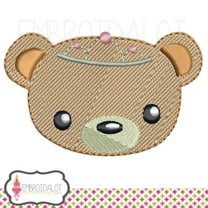 Puede incluir: Diseño bordado de un oso de peluche marrón con una corona rosa y plateada. El oso tiene ojos negros y una nariz marrón claro.