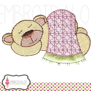 Puede incluir: Diseño bordado de un oso durmiendo con una manta rosa y verde. El oso es amarillo y tiene la nariz marrón.