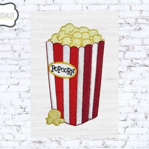 May include: Embroidered design of a popcorn container with red and white stripes, filled with yellow popcorn. The word "POPCORN" is in a yellow oval. A single piece of popcorn is at the bottom. The design is on a white background.