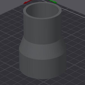 Könnte beinhalten: Ein graues, zylindrisches Objekt mit einem breiten oberen Teil und einer schmaleren, ausgestellten Basis. Das Objekt scheint ein 3D-Modell oder ein digitales Rendering zu sein, vor einem dunkelgrauen Gitterhintergrund. Das Design ist einfach und geometrisch.