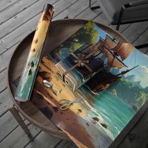 May include: Gift wrap featuring a detailed illustration of a sailing ship on a beach with turquoise water and a brown bow. A roll of matching wrapping paper and a wrapped gift box are on a wooden table with scissors and tape.