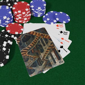 May include: Poker set on a green felt surface. Stacks of red, blue, and black poker chips surround a hand of playing cards. The cards show the number 10 and a unique abstract design on the back.