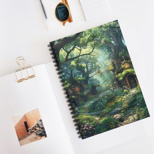 May include: Spiral-bound notebook featuring a vibrant illustration of a whimsical forest scene. The artwork depicts a path winding through lush greenery, with fairy-tale houses nestled among the trees. The cover showcases a detailed fantasy landscape with a variety of colors.