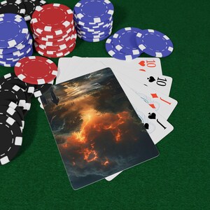 May include: Poker set on a green felt surface. The set includes stacks of red, blue, and black poker chips, playing cards showing the number 10, and a card with a dramatic landscape image.