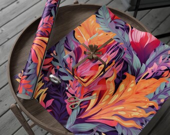 Peut inclure: Un rouleau de papier cadeau et un cadeau emballé avec un ruban marron sont posés sur une table en bois. Le papier et l'emballage cadeau présentent un motif floral vibrant dans les tons orange, rose, violet et sarcelle. Ciseaux et ruban adhésif sont également sur la table.