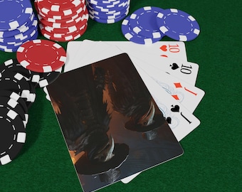 May include: A poker game setup on a green felt surface. Stacks of red, blue, and black poker chips surround a hand of cards, including a Jack of Spades and two 10s. One card features a dark, detailed illustration.