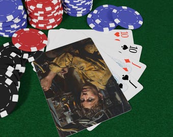 May include: Poker set on a green felt surface. Stacks of red, blue, and black poker chips surround a hand of playing cards. The cards show the ten of hearts, ten of diamonds, ten of spades, and jack of clubs.