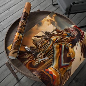 May include: A rolled-up poster and a wrapped gift featuring a Native American portrait with a headdress and face paint. The gift is tied with a brown ribbon. A pair of scissors and a silver ring are also on the table.