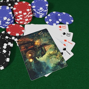 Puede incluir: Juego de póquer con cartas y fichas. Las cartas presentan una ilustración de un tren. Se ven pilas de fichas rojas, azules y negras sobre una superficie verde. Cuatro cartas están abanicadas.