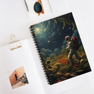 Può includere: Quaderno a spirale con un'illustrazione dettagliata di un astronauta che esplora un paesaggio surreale. La copertina presenta una scena fantasy con un cielo scuro, piante colorate e globi fluttuanti.