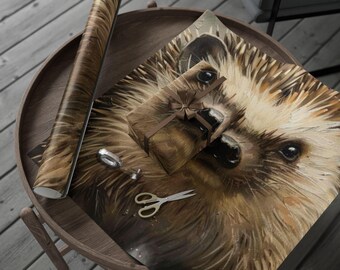 Könnte beinhalten: Eine Rolle braunes Geschenkpapier und ein Geschenk mit braunem Band liegen auf einem Holztisch. Das Geschenkpapier und das Geschenk zeigen eine detaillierte Illustration eines Igels. Eine Schere und ein kleiner silberner Ring liegen ebenfalls auf dem Tisch.
