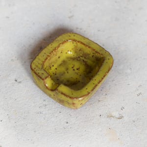 Yellow tiny ashtray for the solitary smoker