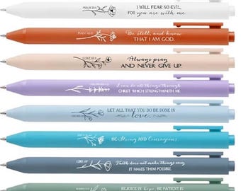 May include: A collection of ten colorful pens with inspirational quotes and floral designs. The pens are in various colors, including green, white, orange, pink, purple, blue, teal, gray, and black. Each pen has a different message.