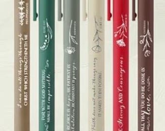 May include: Six pens in various colors: brown, teal, gray, cream, red, and dark brown. Each pen has a matching cap and clip, with inspirational quotes and floral designs printed on the barrel.