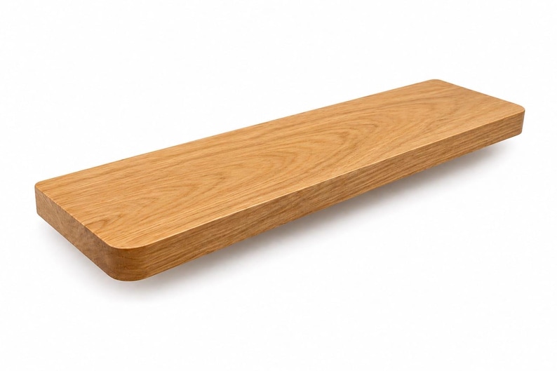 May include: A rectangular wooden shelf with rounded corners. The shelf is made of light brown wood and has a natural wood grain pattern. The shelf is designed to be mounted on a wall and is suitable for displaying items.