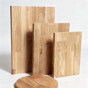 Könnte beinhalten: Eine Sammlung von Holzschneidebrettern und einem runden Servierbrett. Die Bretter sind aus hellem Holz mit sichtbaren Maserungsmustern gefertigt. Die Bretter variieren in Größe und Form, mit rechteckigen und kreisförmigen Designs.