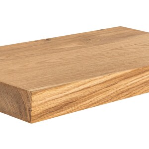 Puede incluir: Una estanter&iacute;a rectangular de madera maciza con un acabado marr&oacute;n claro natural. La veta de la madera es visible y la estanter&iacute;a parece estar hecha de una sola pieza de madera. Los bordes son cuadrados y la estanter&iacute;a est&aacute; lista para su instalaci&oacute;n.