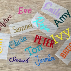 May include: A collection of colorful name decals in various fonts and colors, including pink, gold, teal, green, red, yellow, orange, and blue. Names include Melissa, Eve, Samuel, Rosa, Emily, Amy, Kathy, Olivia, Sarah, Peter, Ivy, Bruce, Toni, and Jasmin.