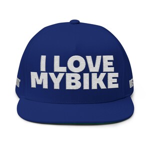 May include: A royal blue baseball cap with the embroidered text "I LOVE MY BIKE" in white. The cap has a flat brim and a green underside. The hat is a classic style, suitable for cycling enthusiasts.