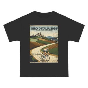 Puede incluir: Camiseta negra con un gráfico de estilo vintage para la carrera ciclista Giro d'Italia 2026. El diseño incluye un ciclista en una carretera sinuosa, con texto que dice "Giro d'Italia 2026" y "Tete de la Course."