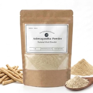 May include: A brown paper bag of Ashwagandha Powder with a clear window, a pile of powder, and a wooden spoon. The bag has a white label with text. Ashwagandha root sticks are to the left.