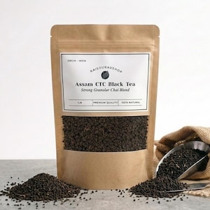 May include: A brown paper bag of Assam CTC Black Tea, with the text "Assam CTC Black Tea Strong Granular Chai Blend". A small pile of tea granules sits in front of the bag, with more tea spilling from a burlap sack.