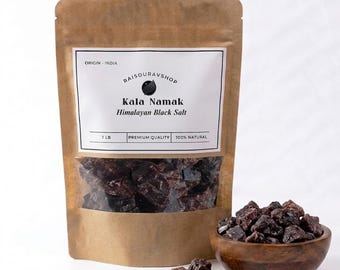 May include: A brown paper bag of Kala Namak Himalayan Black Salt with a clear window, a wooden bowl filled with salt, and loose salt pieces. The bag has a label that reads "RAISOURAVSHOP Kala Namak Himalayan Black Salt" and "1 LB".
