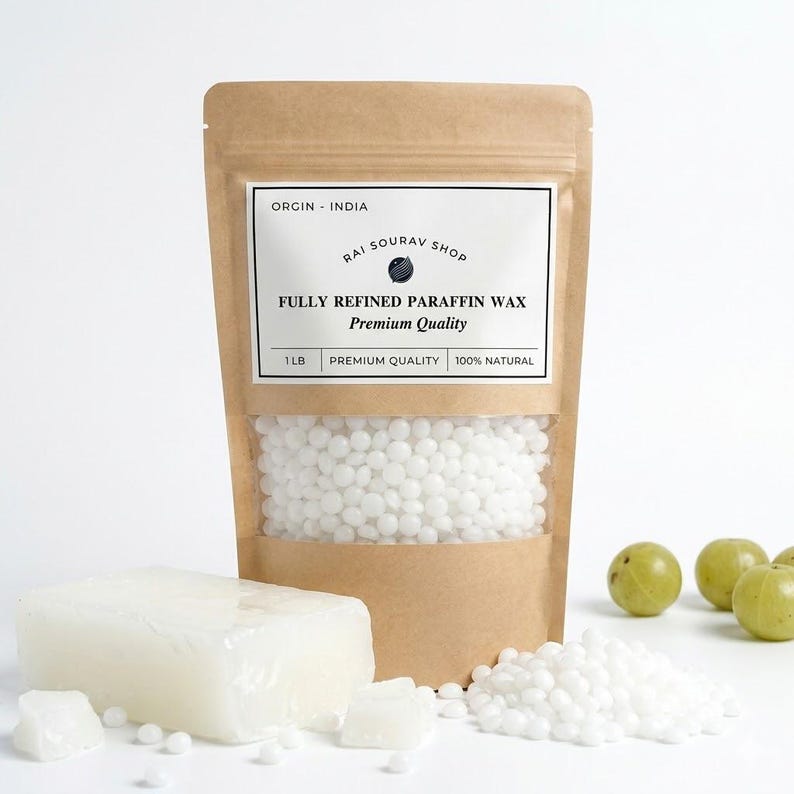 May include: A brown paper pouch containing white paraffin wax beads, labeled "ORGIN - INDIA RAI SOURAV SHOP FULLY REFINED PARAFFIN WAX Premium Quality 1 LB". A rectangular block of translucent white wax and loose wax beads sit in front of the pouch.