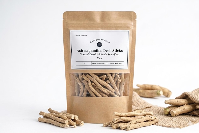 Może przedstawiać: Brązowa papierowa torba z przezroczystym oknem, w kt&oacute;rym widać patyczki ashwagandha desi. Etykieta głosi "Ashwagandha Desi Sticks Natural Dried Withania Somnifera Root". Kilka patyczk&oacute;w jest rozrzuconych wok&oacute;ł torby.