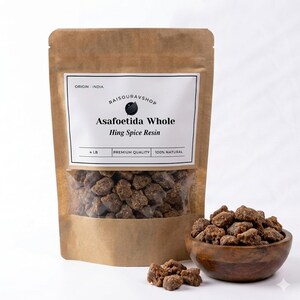 May include: A brown paper bag with a clear window displaying asafoetida whole hing spice resin. A wooden bowl filled with the spice sits to the right. The label reads "Asafoetida Whole Hing Spice Resin" and "4 LB".
