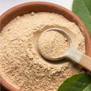 May include: Close-up of a brown ceramic bowl filled with fine, light brown powder, with a matching spoon resting inside. The image includes green leaves and text that reads "ULTRA-FINE, MACRO FOCUS" and "ULTRA-FINE, GRASS-GRINDED TEXTURE".