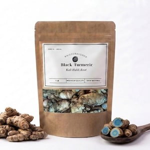 May include: A brown paper bag of Black Turmeric Kali Haldi Root, with a clear window showing the root pieces. A wooden spoon holds sliced turmeric, and a pile of whole turmeric roots sits in front.