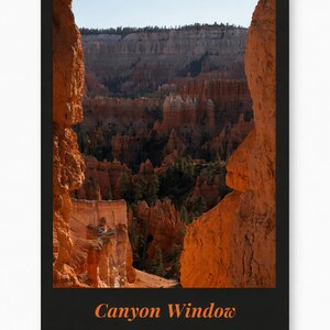 Puede incluir: Una impresión enmarcada que presenta una vista panorámica de un paisaje de cañón. La imagen está enmarcada por dos grandes formaciones rocosas anaranjadas, con el texto "Canyon Window" en naranja en la parte inferior. Las paredes del cañón son una mezcla de naranja y beige.