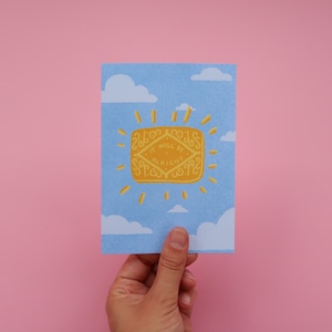 Könnte beinhalten: Eine blaue Karte mit einer weißen Wolke und einem gelben Keks mit dem Text "It will be alright" darauf.
