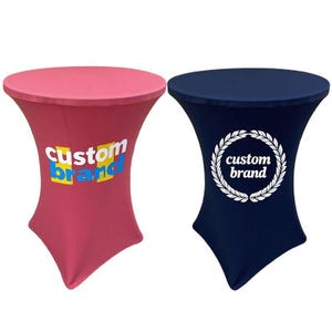 Op de afbeelding: Twee passende statafels. Eén is dieproze met de woorden "custom brand" in blauw en geel. De andere is marineblauw met een witte lauwerkrans en de woorden "custom brand".