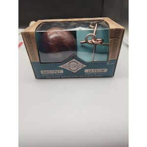May include: A True Genius brand box containing two brainteaser puzzles: a dark brown wooden spherical Shotput puzzle and a metallic Javelin puzzle with silver and copper-colored pieces. The packaging features blue and tan colors with Greek key patterns.