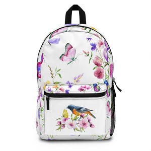 May include: White canvas backpack with a watercolor floral print featuring butterflies, birds, and flowers in shades of pink, purple, blue, and green.
