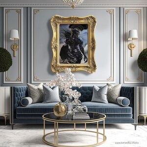 Puede incluir: Una pieza de arte mural rectangular con una figura cl&aacute;sica oscura en un marco dorado ornamentado, centrada sobre un sof&aacute; azul capiton&eacute; con cojines plateados, una mesa de centro redonda de cristal y dos armarios blancos con plantas.