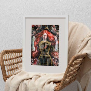 Op de afbeelding: Een ingelijste kunstdruk met een persoon met lang, felrood haar omringd door donkere florale elementen. De persoon draagt een gestructureerd, goudkleurig kooivormig lijfje over een donker kledingstuk, wat een opvallend contrast vormt.