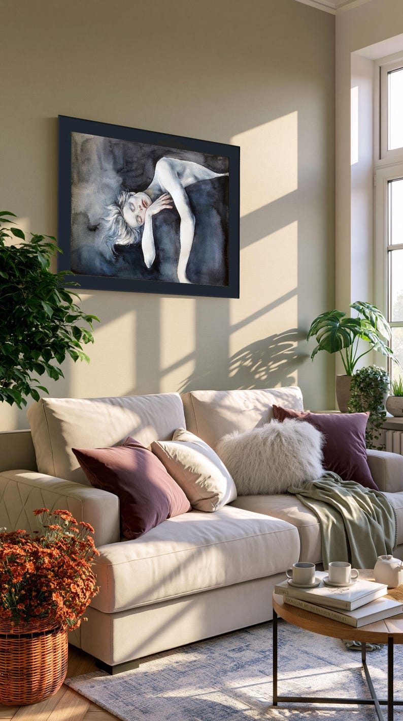 May include: A framed rectangular wall art piece featuring a watercolor painting of a reclining figure with pale skin and light hair, set against a dark, moody, abstract background of deep blues, grays, and blacks, enclosed in a dark frame.
