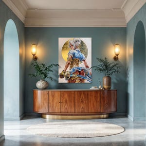 K&ouml;nnte beinhalten: Ein rechteckiger Wandkunstdruck mit einer stilisierten Illustration einer Figur mit wei&szlig;em Haar, die ein blaues Oberteil und ein goldenes Korsett tr&auml;gt und ein Schwert vor einem gro&szlig;en goldenen kreisf&ouml;rmigen Hintergrund h&auml;lt, platziert &uuml;ber einem Sideboard.