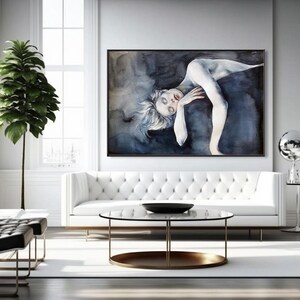 May include: A large rectangular wall art piece featuring a stylized painting of a pale figure with light hair, posed against a dark, moody, swirling blue and black background, framed in a thin black border and displayed in a bright room.